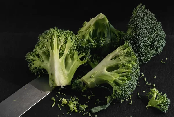 Bloemkool in stukken gesneden op een zwarte achtergrond. Koken concept. Close-up. — Stockfoto