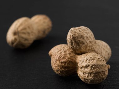 Siyah arka planda üç fıstık, yakın plan. Kabuklu fıstıklar gibi. Süper yemek..