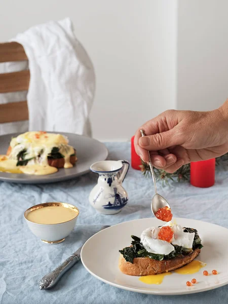 Hollanda yumurtası, tereyağı sosu ve kırmızı havyarlı Benedict yumurtası. Yakın plan. Haşlanmış yumurtalı lezzetli kahvaltı. Dikey yönelim.