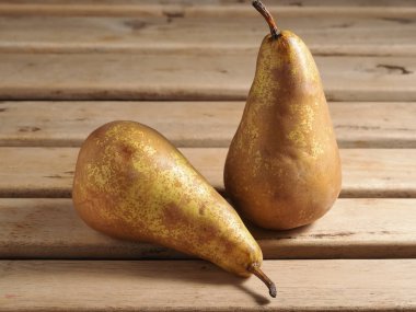 Hafif ahşap zemin üzerinde taze organik armutlar. Sonbahar armut hasadı. Turta yapmak için armutlar.