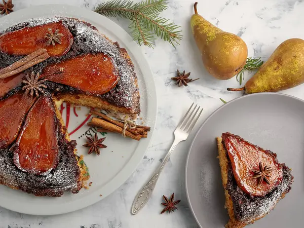 Homemade pie with ricotta and pear. The cake is decorated on top with caramelized pears and powdered sugar. A slice of cake on a plate. Top view. Christmas pie. — Stock Photo, Image