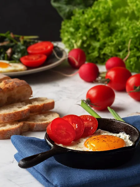 Смачні смажені яйця на сковороді зі смаженим шпинатом та грибами, розташованими на сірому столі. Крупним планом. Вертикальна орієнтація . — стокове фото