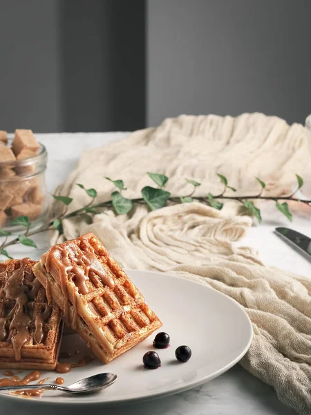 Homemade waffles with delicious caramel sauce on a plate. Belgian waffles with caramel and berries. Selective focus, vertical orientation. Close-up. Sweet dessert. — Stock Photo, Image