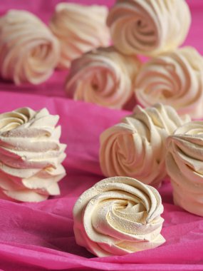 Pembe bir zemin üzerinde yeni hazırlanmış lezzetli bir ev yapımı kayısı (zephyr). Dikey oryantasyon. Şekerlemelere özen göster.