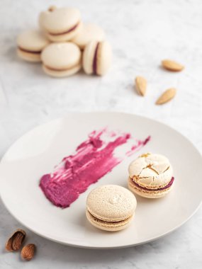 Gri bir tabakta üzümlü ev yapımı badem kurabiyesi. Kurabiyelere odaklan. Badem, kuşüzümü böğürtlenleri ve bir tabakta kurabiye için dolma. Yakın plan..