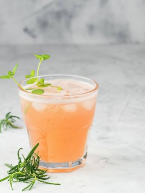 Soğuk limonata, alkollü taze greyfurt suyu ya da wihtout alcohole ve naneli buz küpleri ve gri arka planda biberiye. Uzayı kopyala Yaklaş, seçici odaklanma.