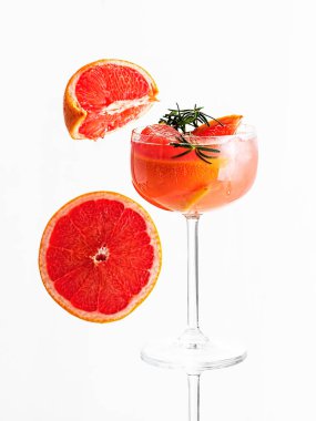 Soğuk limonata taze greyfurt suyu ve buz küpleri beyaz izole arkaplanda bir dilim greyfurt ve dal biberiyesi süsledi. Uzayı kopyala Yaklaş, seçici odaklanma. Greyfurt dilimlerinin yanında.