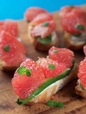 Sağlıklı kahvaltı. Avokadolu tost, yumuşak peynir, ahşap bir masada greyfurt. Süt, kahveyle birlikte bir fincana doldurulur. Yakın plan. Faydalı bir atıştırma. Dikey yönelim.