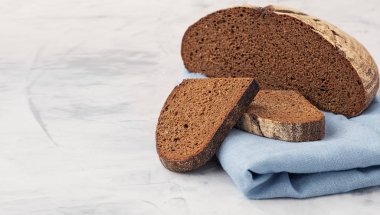 Gri mutfak masasında taze pişmiş çavdar ekmeği. Kapatın, spazmı kopyalayın, at yönünü değiştirin..