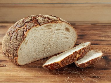 Kırsal masada dilimlenmiş taze pişmiş ekmek. Yakın plan, yatay yönelim.