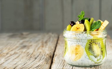 Meyve ve meyveli Chia tohumu pudingi. Sağlıklı kahvaltı veya tatlı, diyet konsepti. Yatay, ahşap kırsal arkaplana yakın plan, kopyalama bölmesi