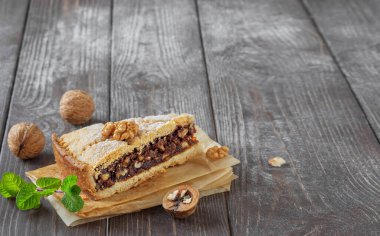 Koyu renkli ahşap arka planda ev yapımı fındıklı kek dilimi. Ceviz ve bir tutam nane. Yakın çekim Kopyalama Alanı