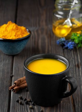 Zerdeçal, bal ve baharattan yapılmış doğal sağlıklı bitki çayıyla dolu bir fincan. Gribe ve soğuk algınlığına karşı bağışıklığı desteklemek için iç. Tıp konsepti ve sağlıklı bir yaşam tarzı. Yakın plan.