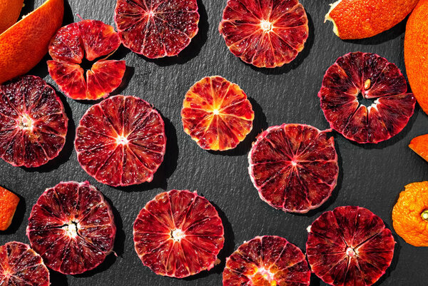 Galette with red Sicilian oranges, sugar and thyme. Galette is located on baking paper, decorated with a sheet of mint. Delicious homemade dessert. Close up, wooden white background