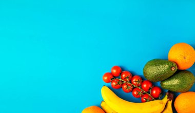 Parlak mavi arka planda çeşitli sağlıklı meyveler. Düz yatıyordu, metin için kopyalama alanı vardı. Çevrimiçi bakkal, sipariş üzerine ürün teslimatı veya bağış