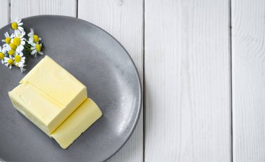 Sandviç için tereyağı ya da gri tabakta yemek. Üst görünüm, metin için kopyalama alanı olan beyaz tahta arkaplan.