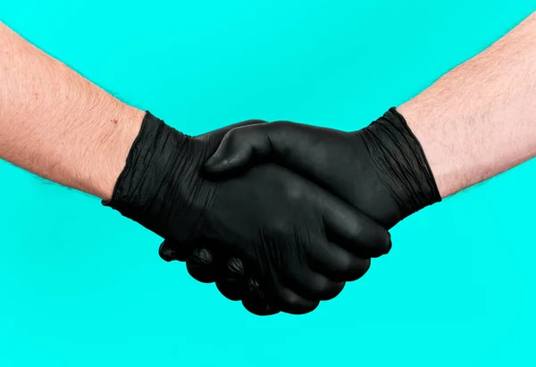 双手戴乳胶黑色手套 双手握着两个人 一个医生 一个病人 个人安全和卫生 薄荷色背景 帮助概念 帮助手 — 图库照片