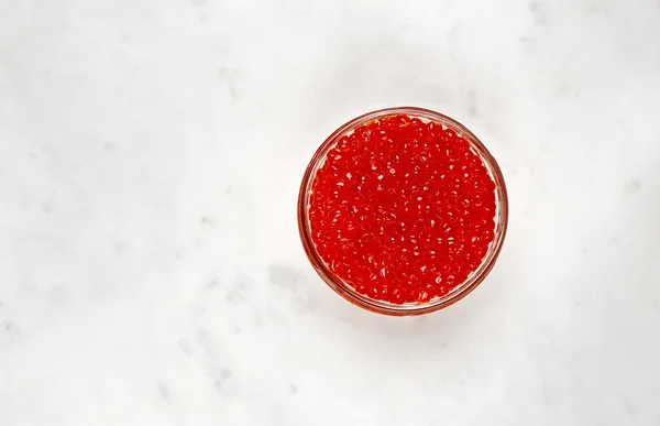 Red caviar on a marble table — Stock Photo, Image