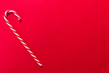 Kırmızı arka planda Noel lolipopu. Boşluğu kopyala.