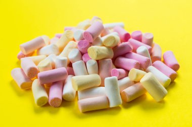 Parlak sarı arka planda çok renkli küçük şekerlemeler..