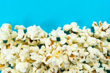 Açık mavi arka planda patlamış mısır. Boşluğu kopyala.