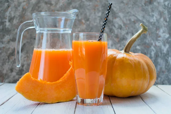 Cam sürahide balkabağı suyu ve arka planda bir bardak balkabağı. Yakın plan..