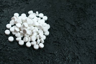 Siyah arka planda bir sürü beyaz hap var. Boşluğu kopyala