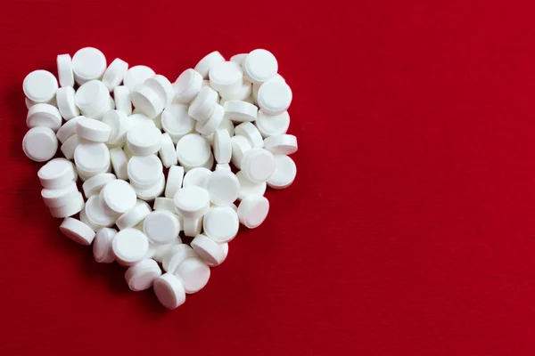 Coração Colocado Pequenas Pílulas Brancas Fundo Vermelho Conceito Doença Cardíaca — Fotografia de Stock