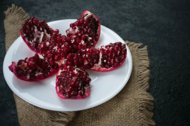 Siyah arka planda beyaz plakalı bir nar. Yakın plan..