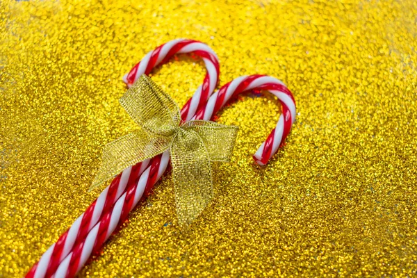Twee Kerstsnoepjes Met Een Gouden Strik Een Glanzende Gouden Achtergrond — Stockfoto