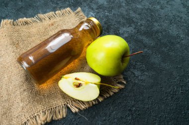  Şişede elma suyu ve siyah arka planda yeşil elma suyu. Düz yatıyordu. Boşluğu kopyala.