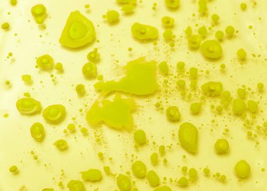 Abstract background from drops of yellow paint on glass.