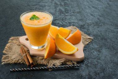 Siyah arka planda bir bardak taze portakal suyu. Uzayı kopyala Ferahlatıcı bir yaz içeceği konsepti.