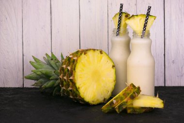 İki şişe ananas, sağlıklı meyve suyu ve ananas..