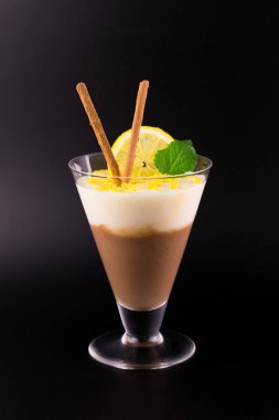 Çikolata ve limonlu tatlı (puding) siyah arka planda limon lezzeti ile süslenir.