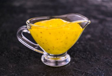 Siyah bir arka planda cam soslu hardal portakal sosu. Yakın plan..