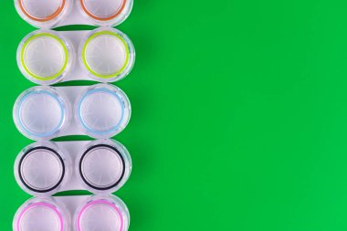 Yeşil arka planda lensler için bir sürü konteynır. Boşluğu kopyala.