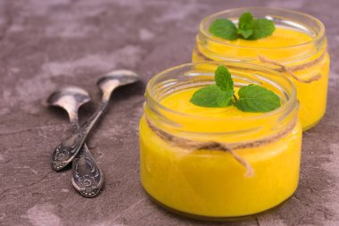 Portakallı Kürt mü yoksa düşük kavanozlu tatlı mı? Turuncu yaz, gri arka planda ferahlatıcı bir tatlı..