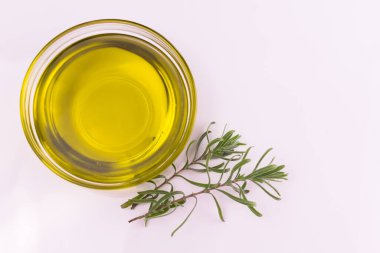 Beyaz arka planda bir tabakta biberiye filizi olan zeytinyağı. Uzayı kopyala Üst görünüm.