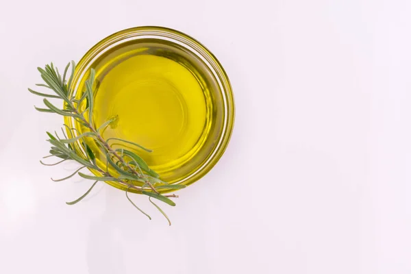 Beyaz arka planda bir tabakta biberiye filizi olan zeytinyağı. Uzayı kopyala Düz yatıyordu.