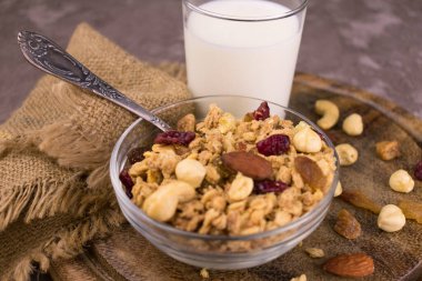 Ceviz ve böğürtlenli granola ve tahtanın üzerinde bir bardak süt. Sağlıklı ve lezzetli kahvaltı kavramı. Yakın plan..