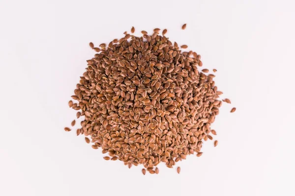 Beyaz arka planda bir avuç keten tohumu. Üst görünüm.