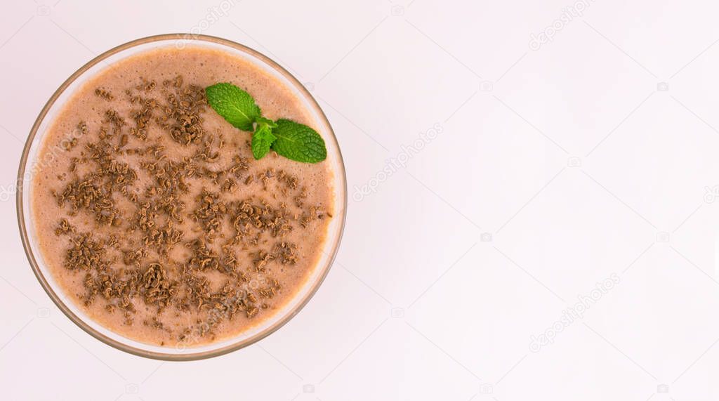 Chocolate milkshake in a glass on a white background. View from the top. Copy space.