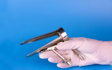 Doktorlardaki jinekolojik ayna mavi arka planı gösteriyor. Uzayı kopyala Jinekolojik muayene için araç.