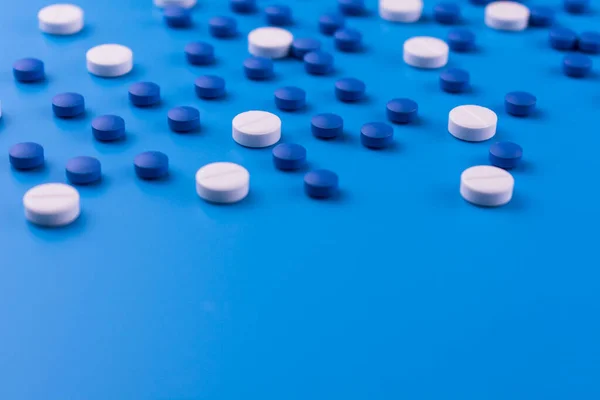 青の背景に白と青の錠剤の医学的背景多くの鎮静薬 スペースをコピー — ストック写真