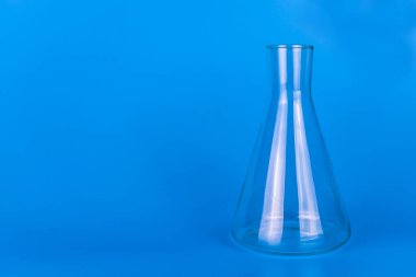 Mavi arka planda tıbbi laboratuvar şişesi. Boşluğu kopyala.