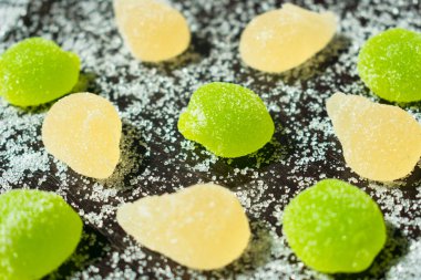 Siyah arka planda çok renkli marmelat ve serpiştirilmiş şeker..