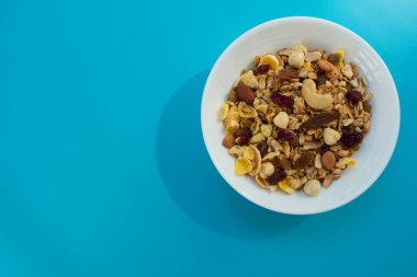 Mavi arka planda kullanışlı granola tabağı. Düz yatıyordu. Boşluğu kopyala.