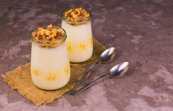 Healthy dessert with granola, banana yogurt in a jar. Copy space.