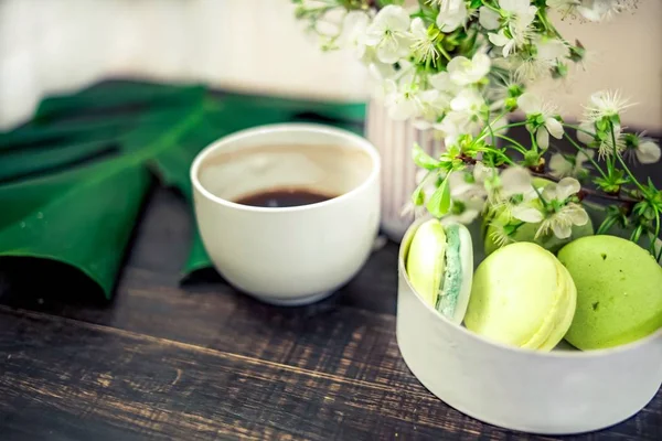 Kahve ya da çay için ahşap bir masa üzerinde yeşil macarons